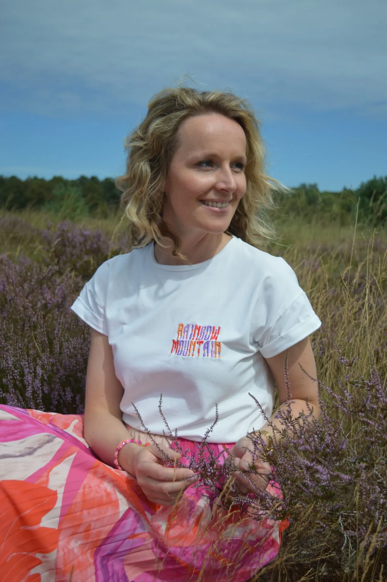 Marloes zittend in de bloeiende heide